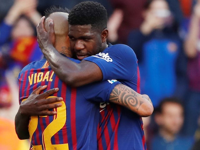 Barcelona's Samuel Umtiti hugs teammate Arturo Vidal during the team's La Liga clash with Getafe on May 12, 2019