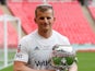 AFC Fylde joker Danny Rowe poses with the FA Trophy partly on his head on May 19, 2019