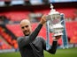 Manchester City manager Pep Guardiola holds the FA Cup aloft on May 18, 2019