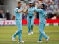 England's Chris Woakes celebrates taking the wicket of New Zealand's Tom Latham with Eoin Morgan on July 14, 2019
