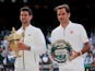 Serbia's Novak Djokovic celebrates winning the final as he and Switzerland's Roger Federer pose with their trophies on July 14, 2019