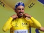 Deceuninck-Quick Step rider Julian Alaphilippe of France celebrates on the podium, wearing the overall leader's yellow jersey on July 8, 2019