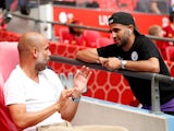 Manchester City manager Pep Guardiola speaks with Riyad Mahrez before the match on August 4, 2019