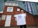A Bury fan holds up a T-shirt outside Gigg Lane on August 23, 2019