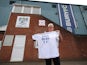 A Bury fan holds up a T-shirt outside Gigg Lane on August 23, 2019