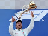 Mercedes' Lewis Hamilton celebrates with a trophy on the podium after winning the Russian Grand Prix on September 29, 2019
