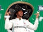 Lewis Hamilton celebrates winning the race on the podium whilst wearing a sombrero on October 27, 2019