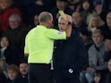 Tottenham Hotspur manager Jose Mourinho is shown a yellow card by referee Mike Dean on January 1, 2020