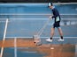 A groundstaff prepares the court ahead of play following a dust storm on January 23, 2020