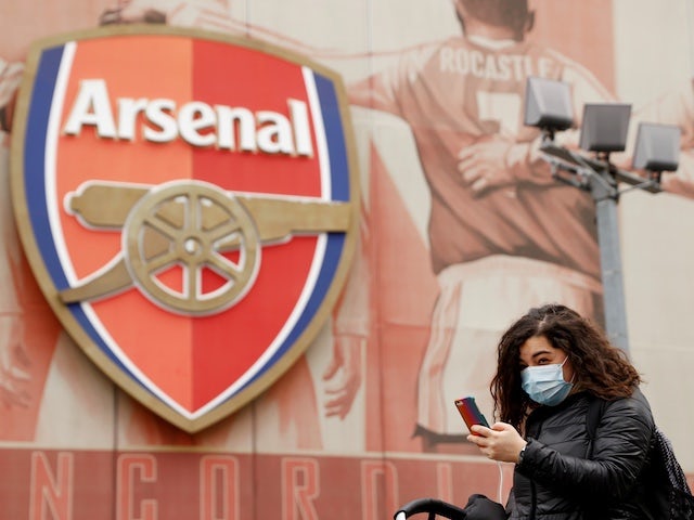 A woman wearing a mask walks by the Emirates Stadium after manager Mikel Arteta tested positive for coronavirus and their Premier League match against Brighton on Saturday has been cancelled on March 13, 2020