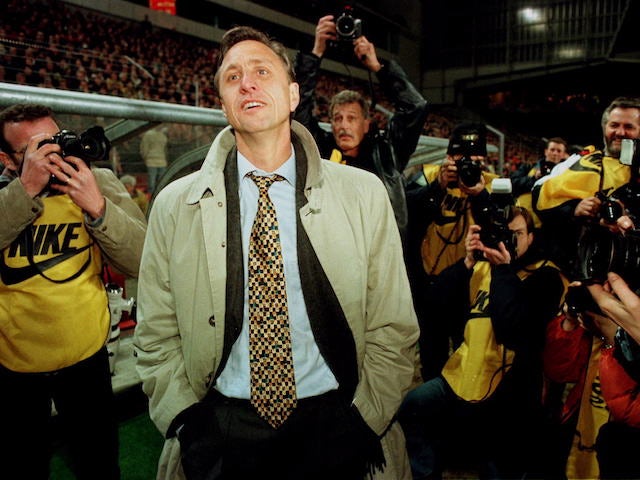Barcelona coach Johan Cruyff looks on as he is surrounded by photographers after his team defeated Dutch PSV Eindhoven in the second leg of the UEFA Cup quarter final match in Eindhoven, March 19 1996