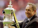 Former Liverpool boss Gerard Houllier celebrates with the FA Cup trophy in 2001