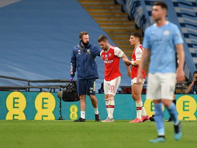 Arsenal defender Shkodran Mustafi is helped off the pitch against Manchester City in their FA Cup semi-final on July 18.