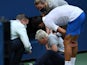Novak Djokovic attends to a linesperson who was struck by a ball at the US Open on September 6, 2020