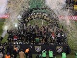 Columbus Crew players celebrate on stage with the MLS Cup championship trophy after defeating the Seattle Sounders in the 2020 MLS Cup Final at MAPFRE Stadium in December 2020