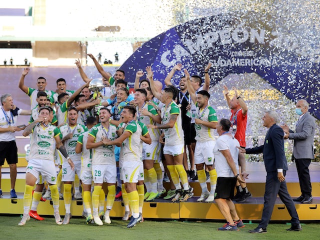 Defensa y Justicia players celebrate with the trophy after winning the Copa Sudamericana in January 2021