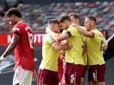 James Tarkowski celebrates scoring Burnley's first goal with teammates against Manchester United in the Premier League on April 18, 2021