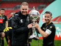 Harrogate Town's Josh Falkingham and manager Simon Weaver celebrate with the trophy after winning the FA Trophy Final on May 3, 2021