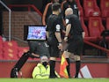 Referee Anthony Taylor consults the pitchside VAR during the Premier League clash between Manchester United and Liverpool on May 13, 2021