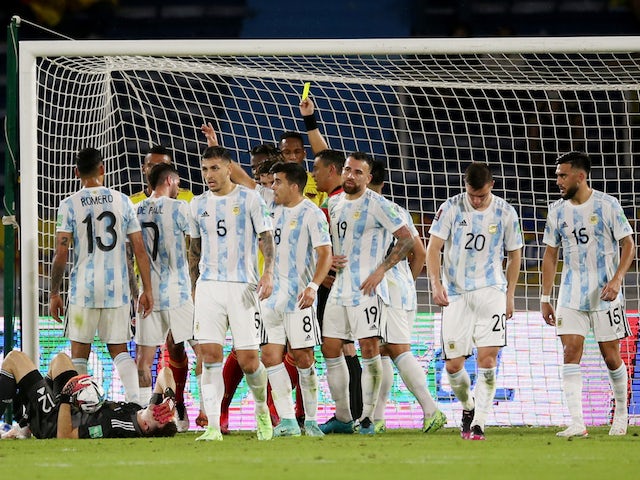 Colombia's Yerry Mina is shown a yellow card by referee Roberto Tobar as Argentina's Emiliano Martinez sustains an injury on June 8, 2021