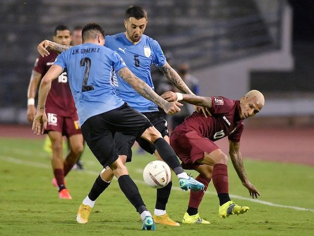 Uruguay's Jose Gimenez and Matias Vecino in action with Venezuela's Romulo Otero on June 8, 2021