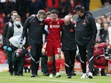 Liverpool's Andrew Robertson is helped off the pitch after sustaining an injury as manager Jurgen Klopp looks on on August 8, 2021