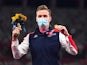 Gold medallist Karsten Warholm of Norway celebrates on the podium as he wears a face mask on August 3, 2021