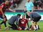 Lille's Sven Botman receives medical attention after sustaining an injury as Burak Yilmaz looks on on September 14, 2021