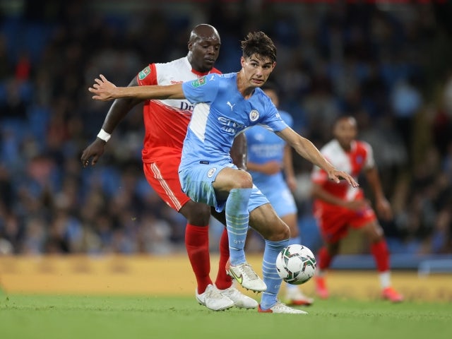 Manchester City's Finley Burns pictured with Wycombe's Adebayo Akinfenwa on September 21, 2021