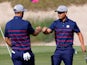 Team USA's Xander Schauffele and Dustin Johnson react during the Ryder Cup on September 24, 2021