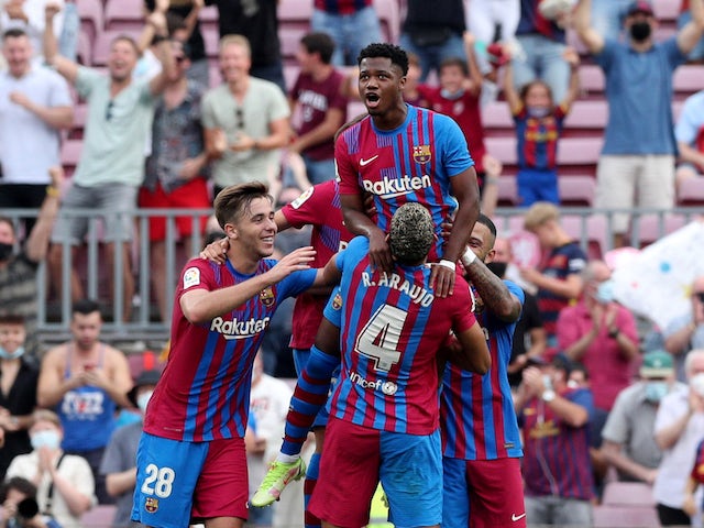 Barcelona's Ansu Fati celebrates scoring their third goal with Ronald Araujo and teammates on September 27, 2021