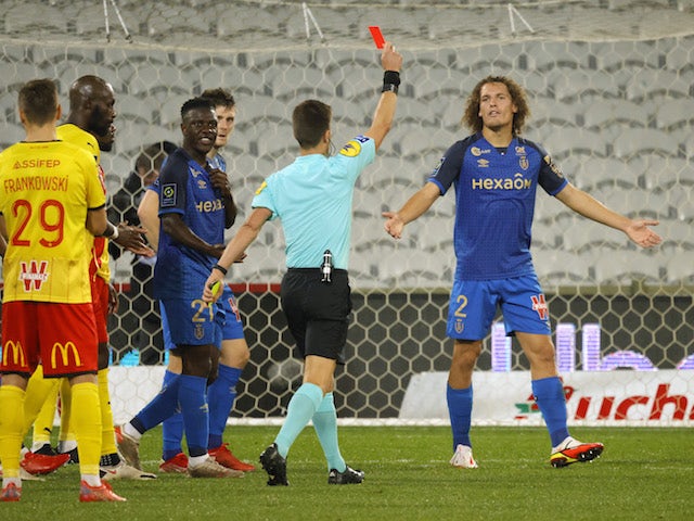 Reims' Wout Faes reacts as referee Benoit Bastien sends off Stade de Reims' Hugo Ekitike (not pictured) after a VAR review on October 1, 2021