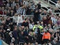 Newcastle United fans attract the attention of the officials to a medical emergency in the stands on October 17, 2021