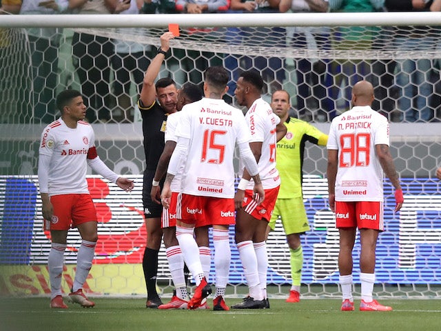 Internacional's Edenilson is shown a red card by referee Braulio da Silva Machado
