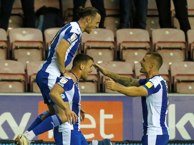 Wigan Athletic's Charlie Wyke celebrates scoring their first goal with teammates on October 19, 2021