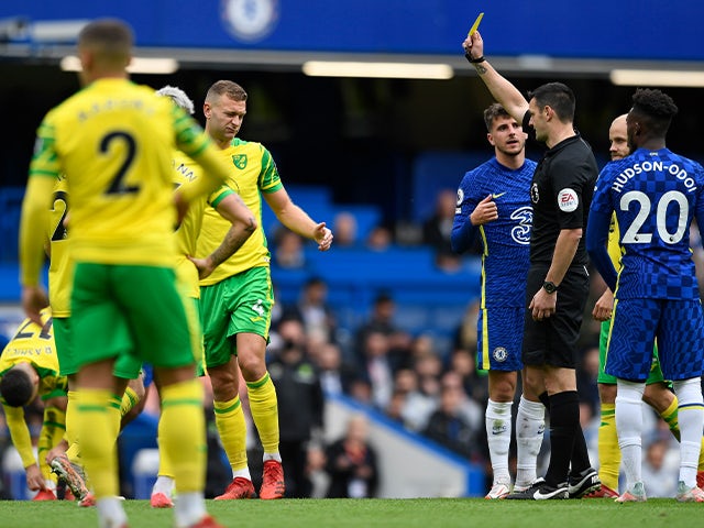 Norwich City's Ben Gibson is shown a yellow card by referee Andy Madley against Chelsea on October 23, 2021