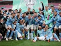 Manchester City players celebrate with the trophy after winning the EFL Cup on April 25, 2021