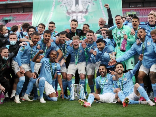 Manchester City players celebrate with the trophy after winning the EFL Cup on April 25, 2021