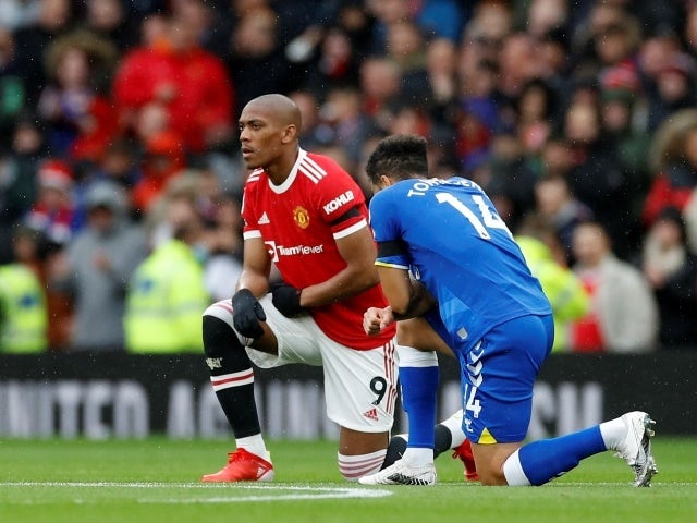 Manchester United's Anthony Martial and Everton's Andros Townsend take a knee before the match, October 2, 2021