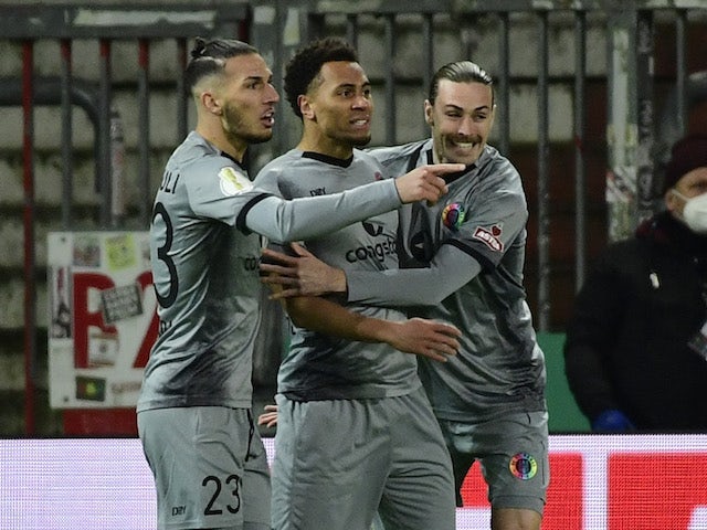 St Pauli's Etienne Amenyido celebrates scoring their first goal with Leart Paqarada and Jackson Irvine on January 18, 2022