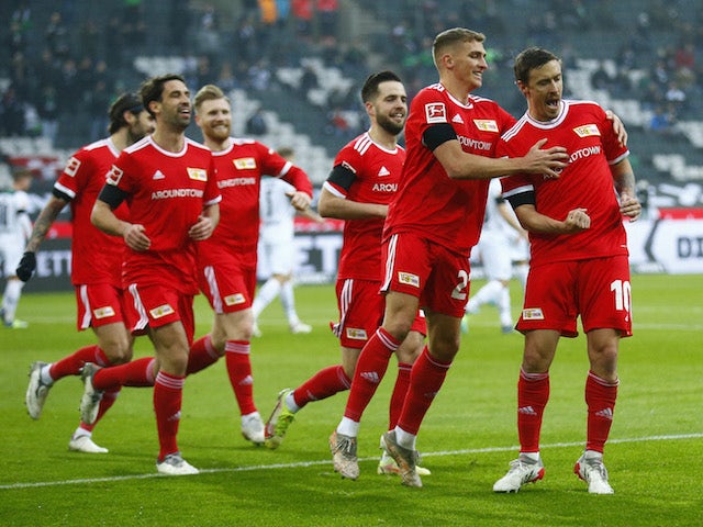 Union Berlin's Max Kruse celebrates scoring their first goal with Grischa Promel and teammates on January 22, 2022