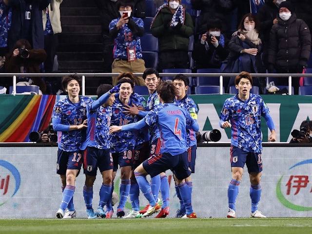 Japan's Takumi Minamino celebrates scoring their first goal with teammates on February 1, 2022