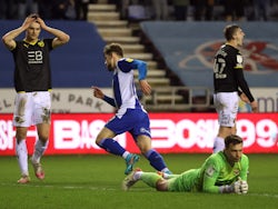 Wigan Athletic's Callum Lang celebrates scoring their first goal as Oxford United's Jack Stephens and teammates react on February 1, 2022