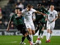  Milton Keynes Dons' Scott Twine in action with Plymouth Argyle's James Wilson and Panutche Camara on December 8, 2021