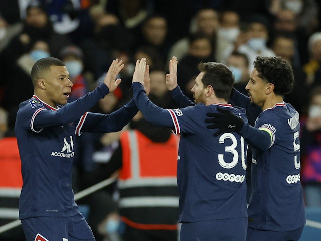 Paris Saint-Germain's (PSG) Kylian Mbappe celebrates scoring their first goal with Lionel Messi and Marquinhos on February 26, 2022