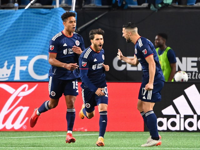 New England Revolution midfielder Carles Gil (10) reacts with midfielders Brandon Bye (15) and Sebastian Lletget (17) after converting a penalty kick in the second half at Bank of America Stadium on March 20, 2022.