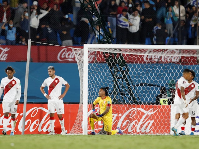 Carlos Zambrano de Perú y sus compañeros lucen deprimidos después de que el uruguayo Giorgian de Arrascaeta anotara su primer gol el 24 de marzo de 2022.