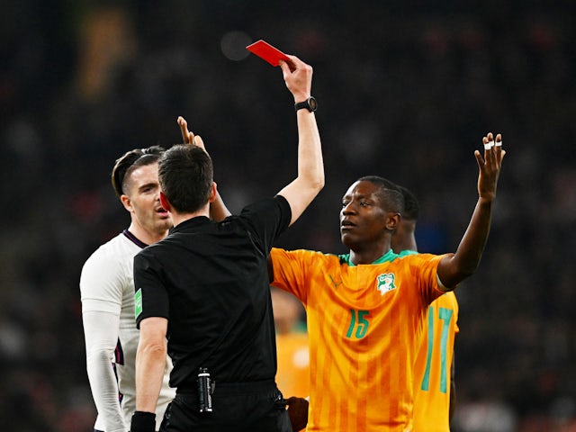 Ivory Coast's Serge Aurier is shown a red card by referee Erik Lambrechts as Ivory Coast's Max Gradel reacts on March 29, 2022