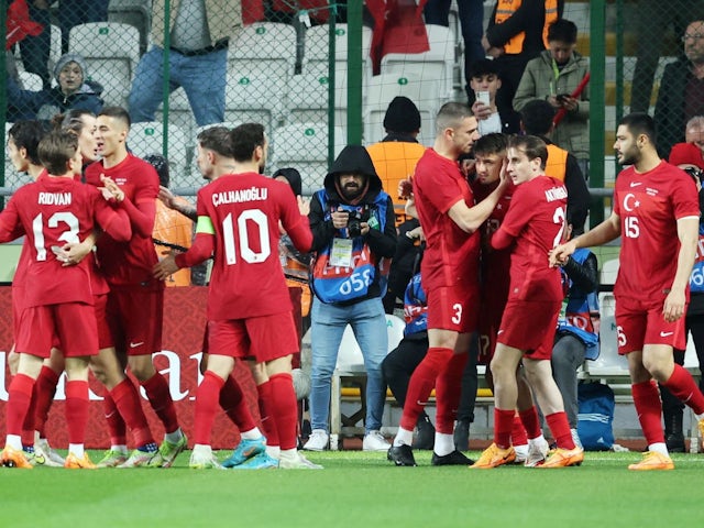 Cengiz Ander din Turcia sărbătorește că a marcat primul său gol cu ​​colegii săi pe 29 martie 2022