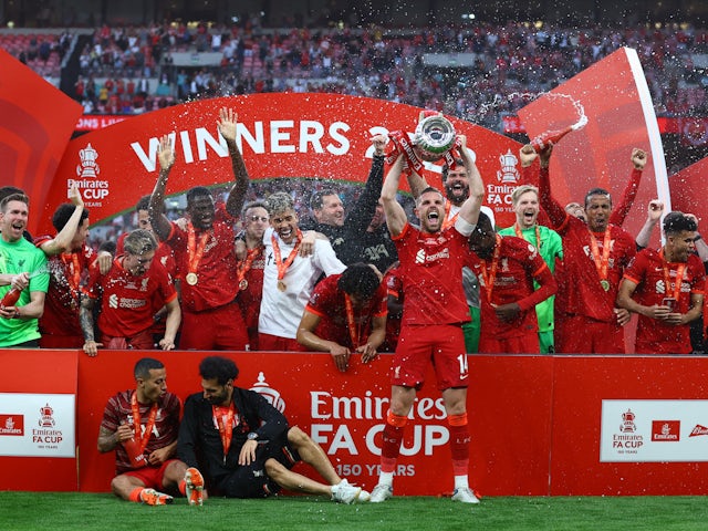 Liverpool's Jordan Henderson lifts the trophy as they celebrate after winning the FA Cup on May 14, 2022